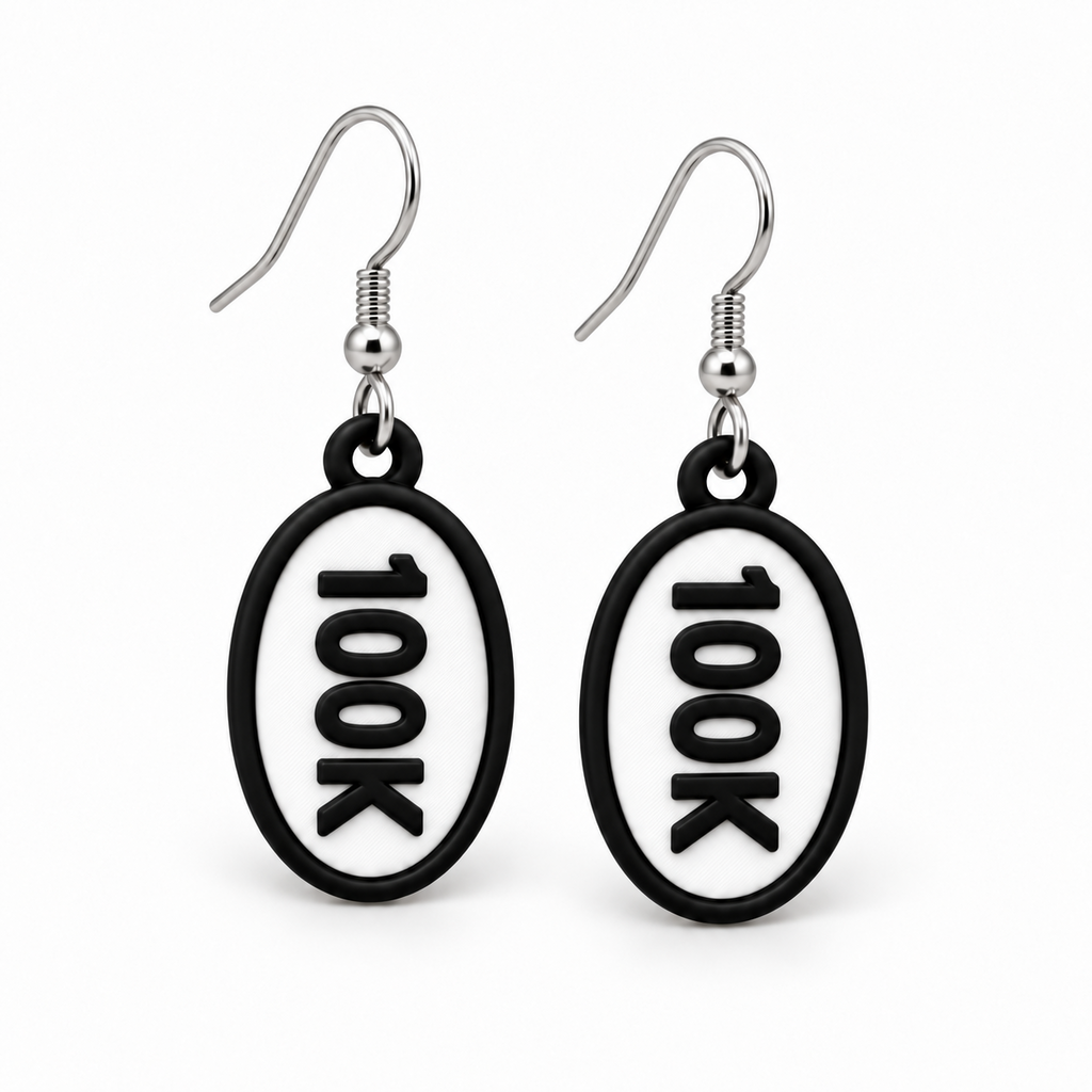 Close-up pair of black-and-white 100K oval distance earrings
