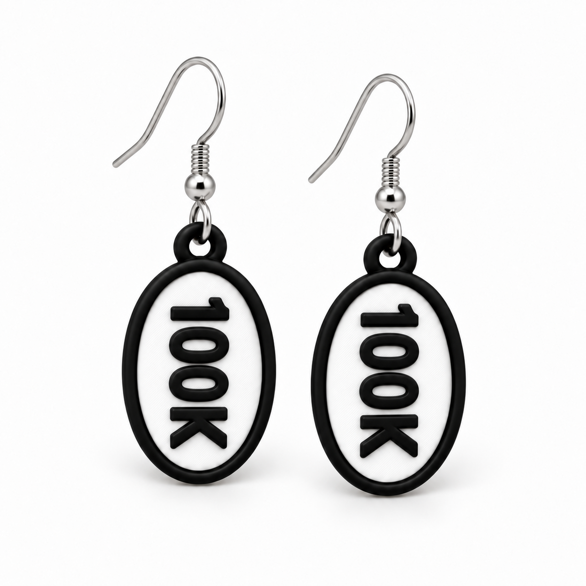 Close-up pair of black-and-white 100K oval distance earrings