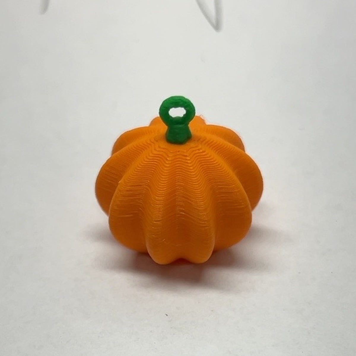 Dimensional orange ribbed pumpkin earring with green stem