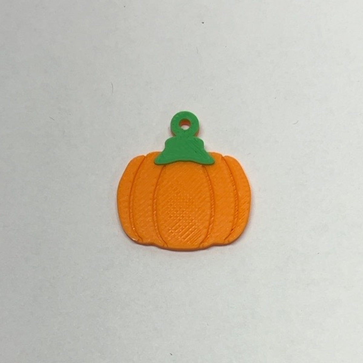 Flat orange pumpkin earring with green stem and printed hanging loop