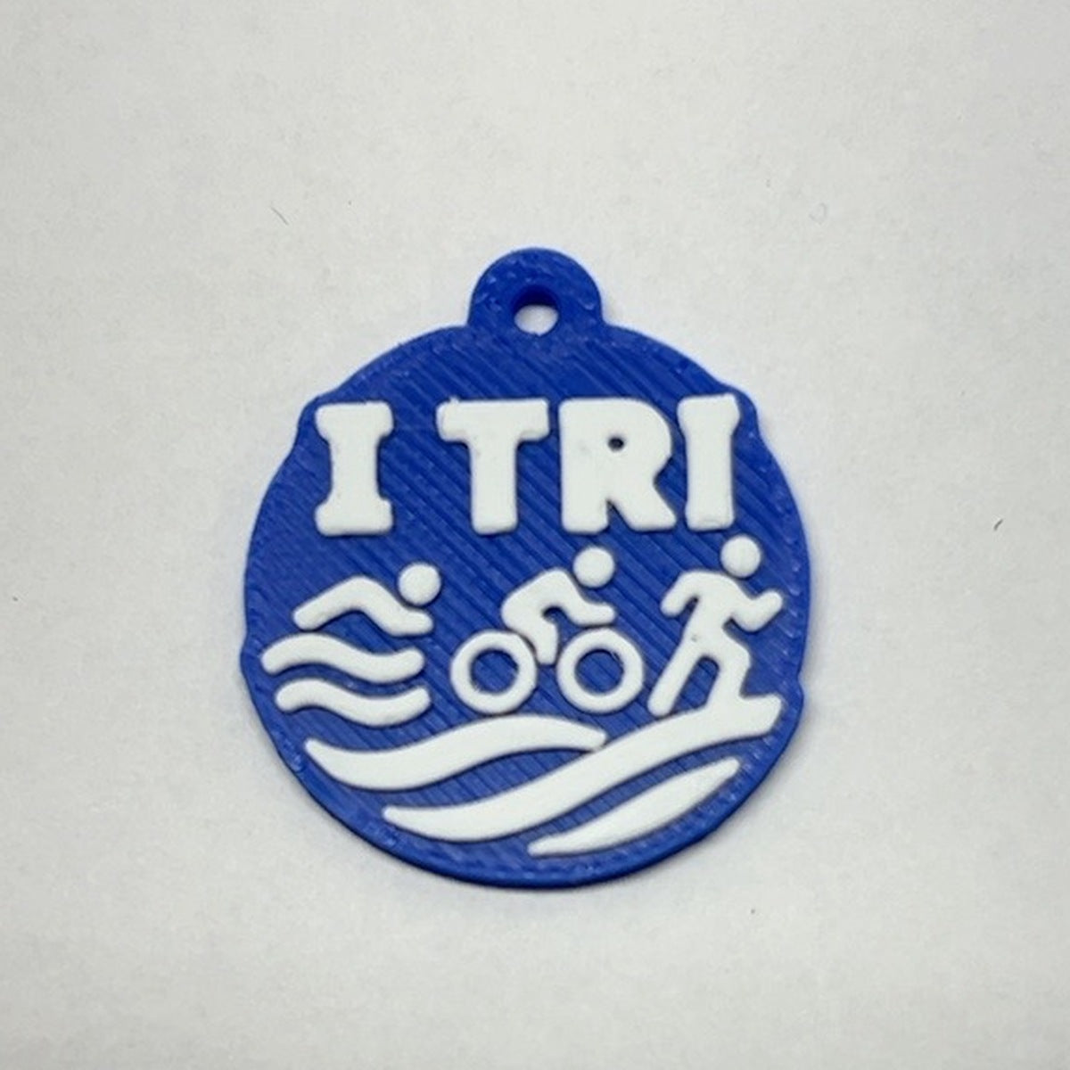 Blue and white TRI 3D printed earring with swim bike run icons